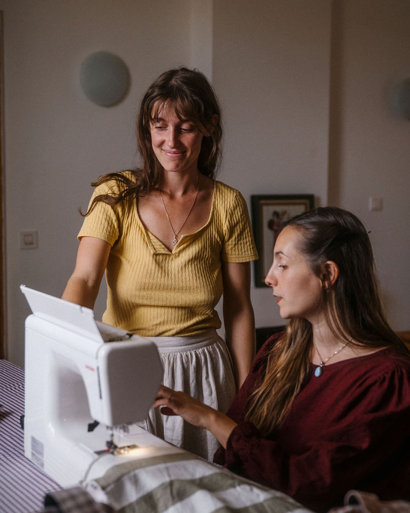 Manon guide une élève à la machine à coudre